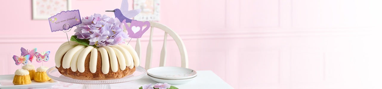 Table featuring Butterflies Bundtinis and Best Mom A'round Bundt cake.