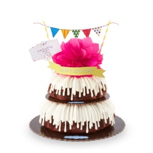 8 inch and 10 inch Bundt cakes, stacked on top of each other, with pink bow, message card, and banner