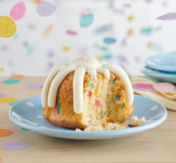 Individual bundtlet crowned with signature frosting on a plate