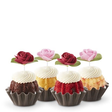 Four Bundtinis in variety of flavors with cream cheese frosting and pink and red rose toppers for Mother's Day or spring celebrations.