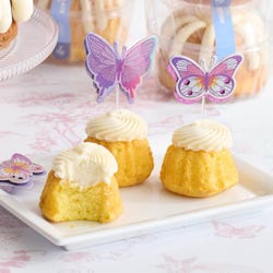 Bundtinis® topped with frosting and decorated with purple butterflie toppers