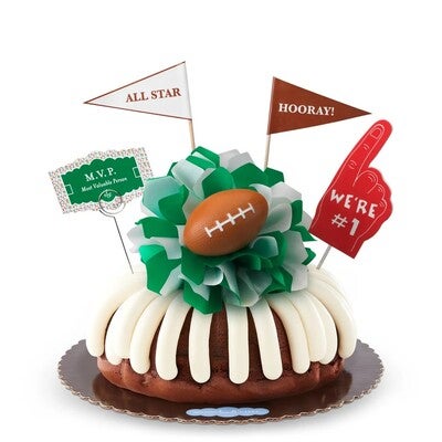 Bundt Cake crowned with signature frosting with paper bows, football decor -- bow colors are customizable -- shop now.