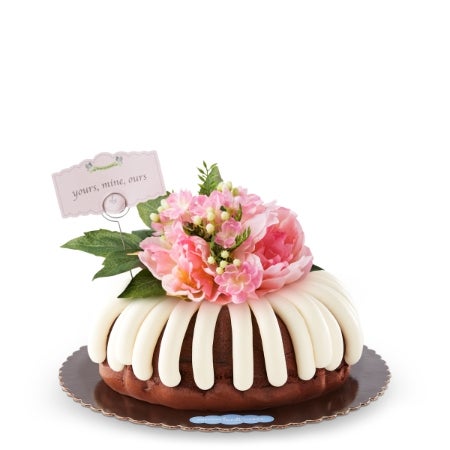 Yours, Mine, Ours Bundt Cake with cream cheese frosting, pink peonies, and yours mine ours sign for weddings, anniversaries, and romantic celebrations.