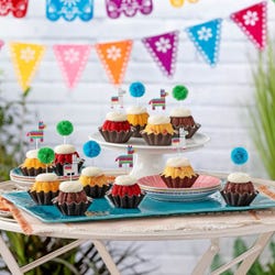 Cupcake like bundt cakes with frosting and decorated with party pinatas and poms. 