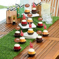 Mini bundt cakes topped with frosting in assorted flavors with a football topper and a #1 foam finger.