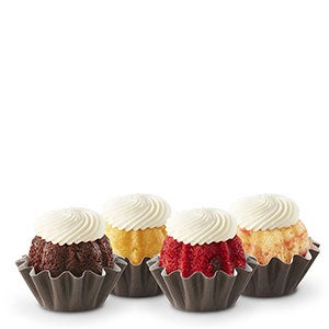 Four Bundtinis sitting in a row. Chocolate, Lemon, Red Velvet, and White Chocolate Raspberry