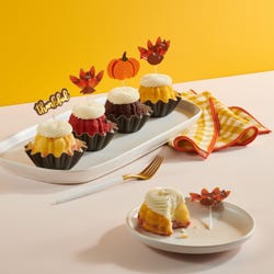 Thankful Turkey Bundtinis® topped with frosting and decorated with pumpkin and turkey toppers as well as a topper with Thankful written in cursive. 