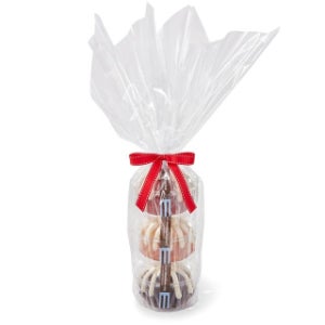 Three Bundtlets stacked on top of each other wrapped in cellophane and tied together with a red bow